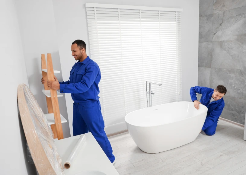 Two men setting up bathtub and shelves