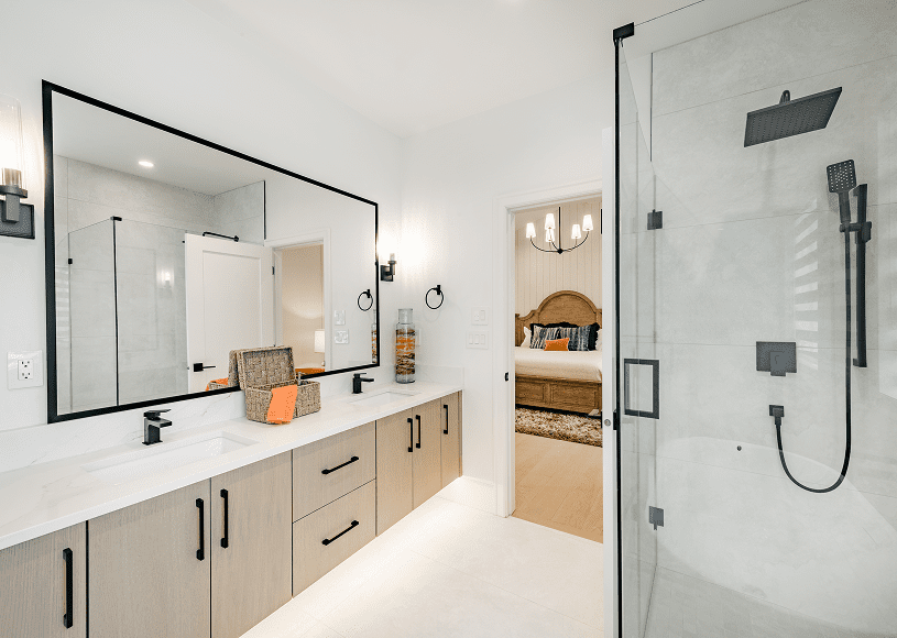 Modern bathroom with double vanity and glass shower.
