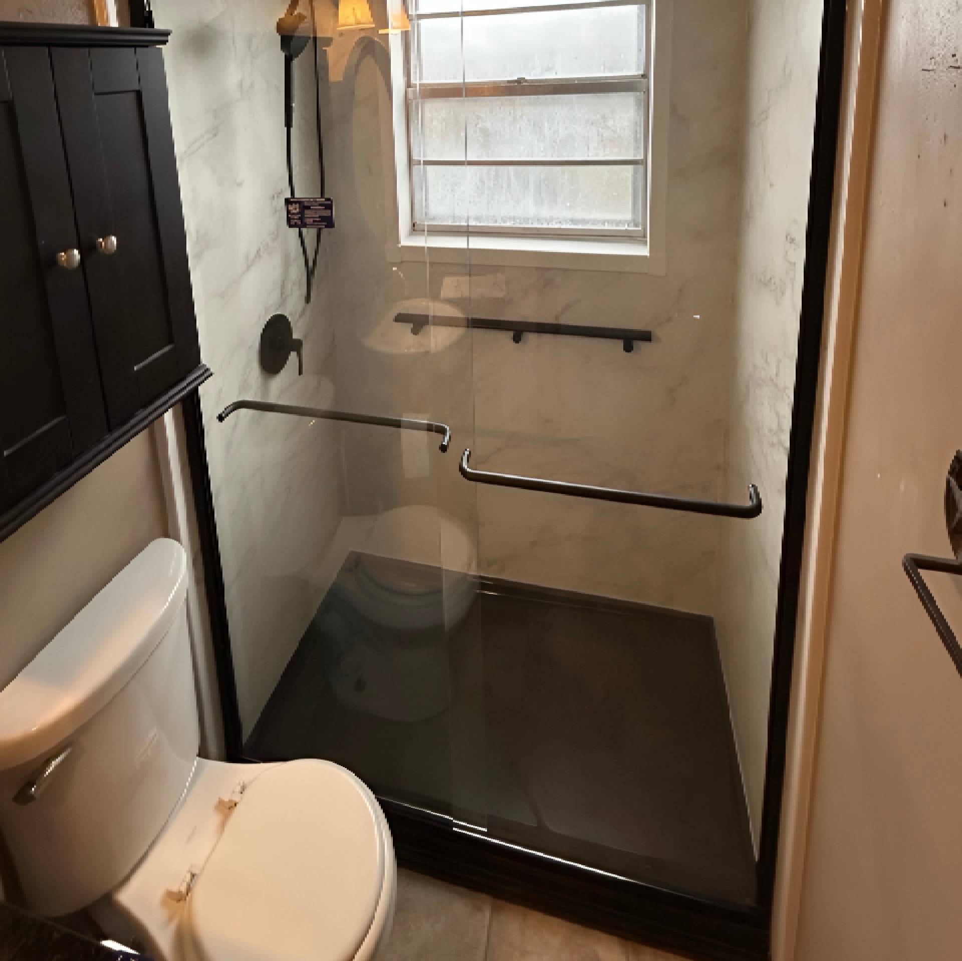 Modern bathroom with glass shower and minimalistic design.