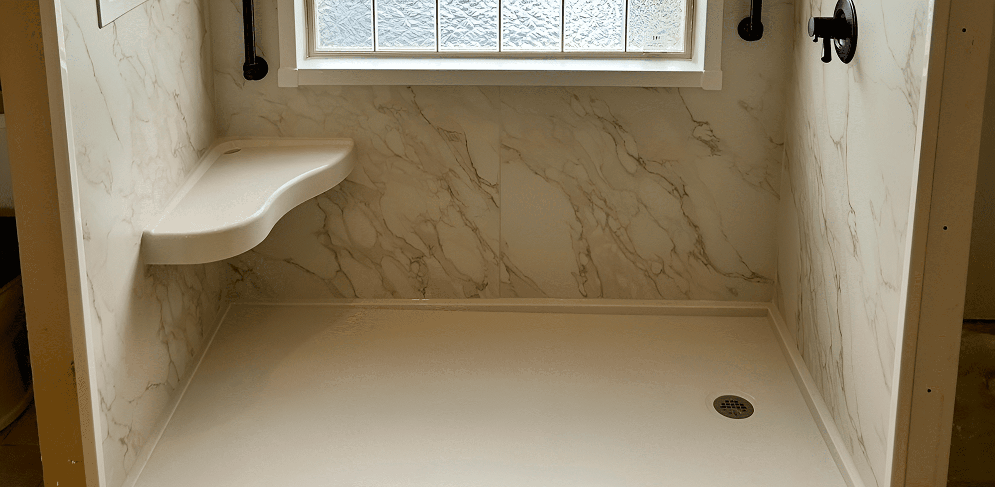 Minimalist bathtub corner with marble walls and frosted window.