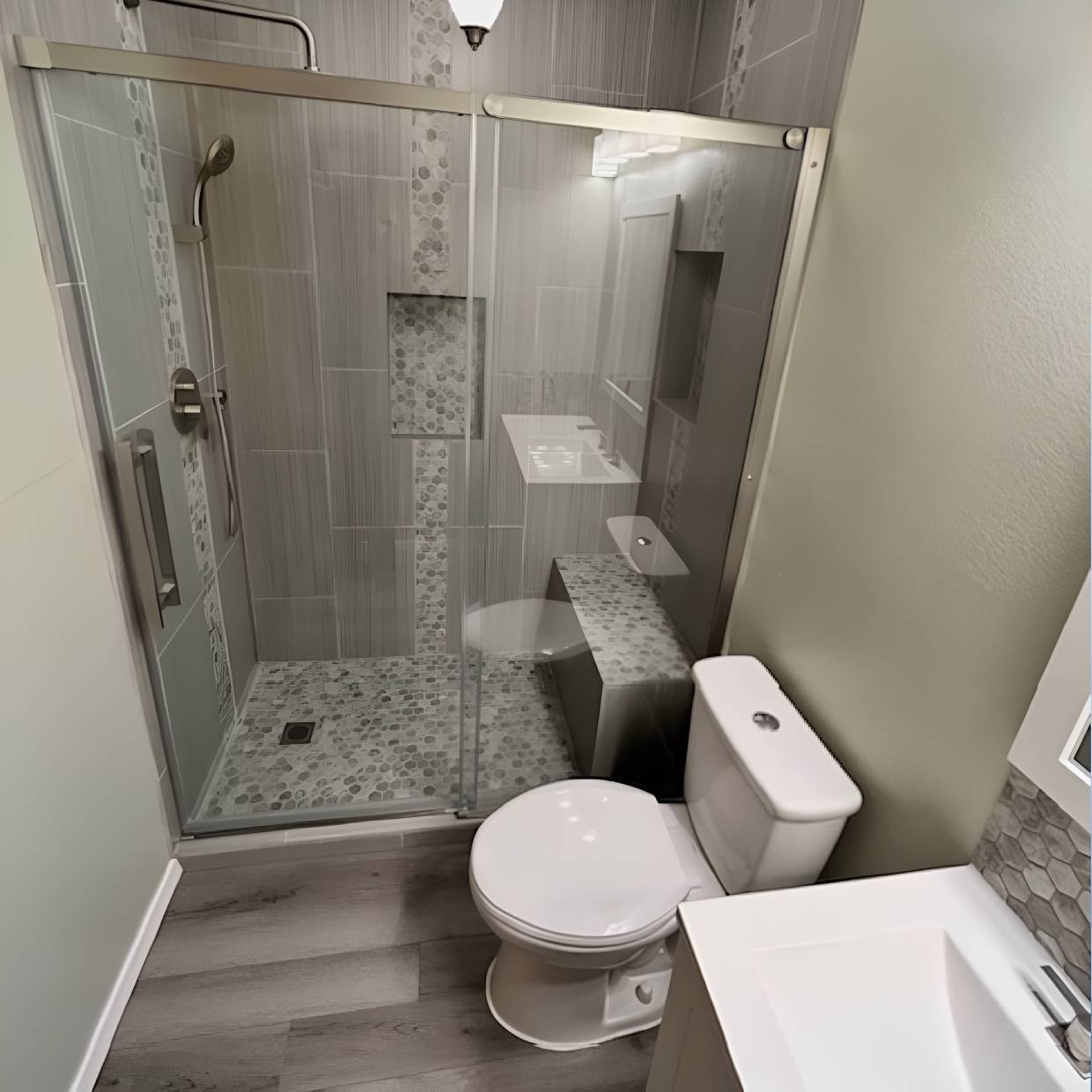 Modern bathroom with glass shower enclosure and white fixtures.