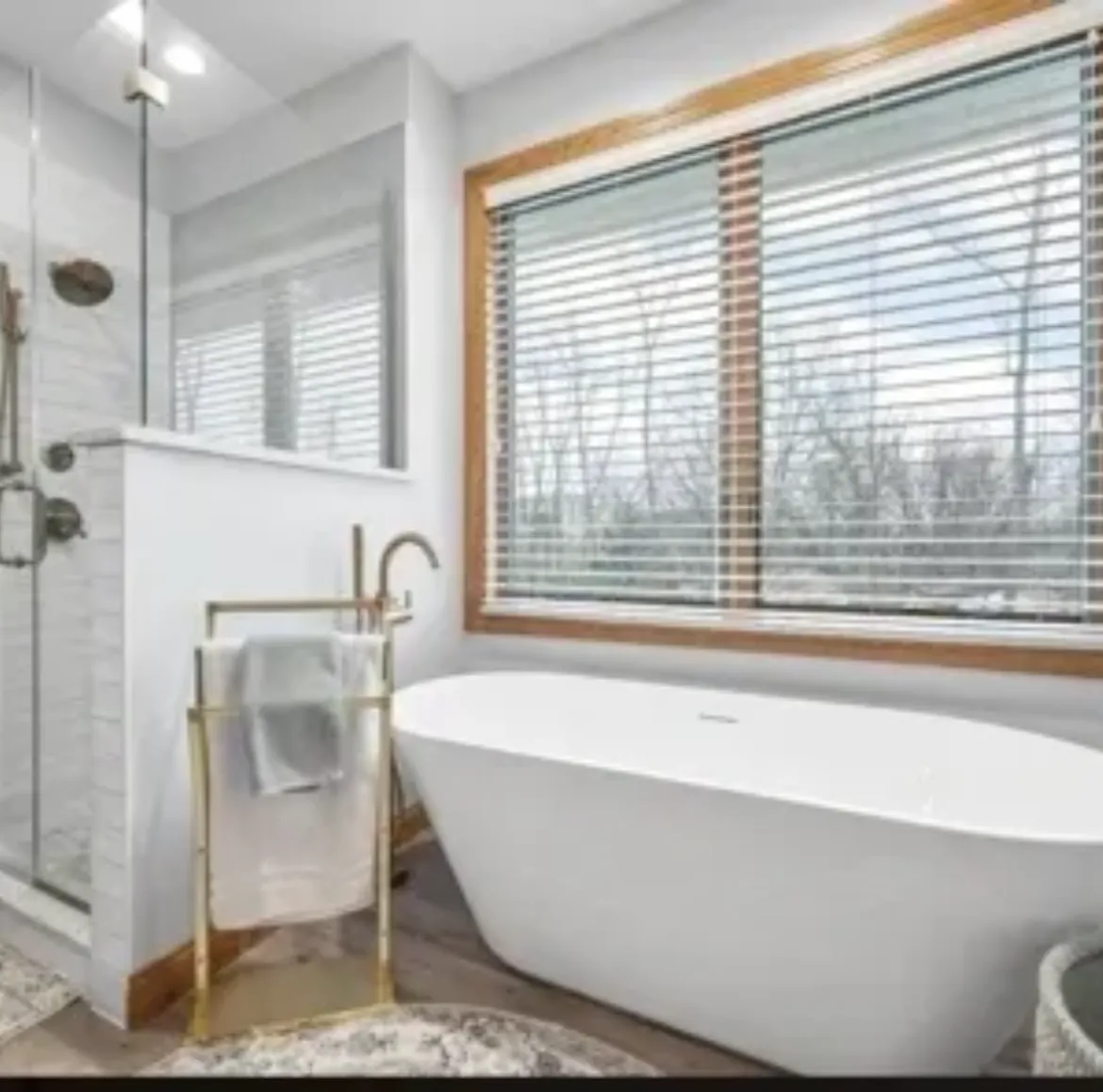 Modern bathroom with freestanding tub and large window.
