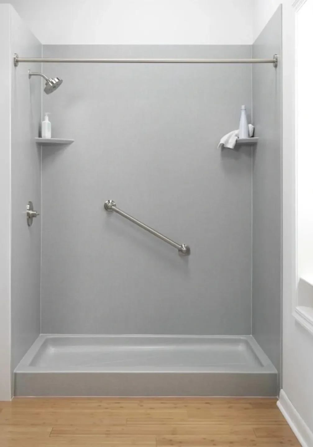 Minimalist shower with built-in corner shelves and a grab bar for safety.
