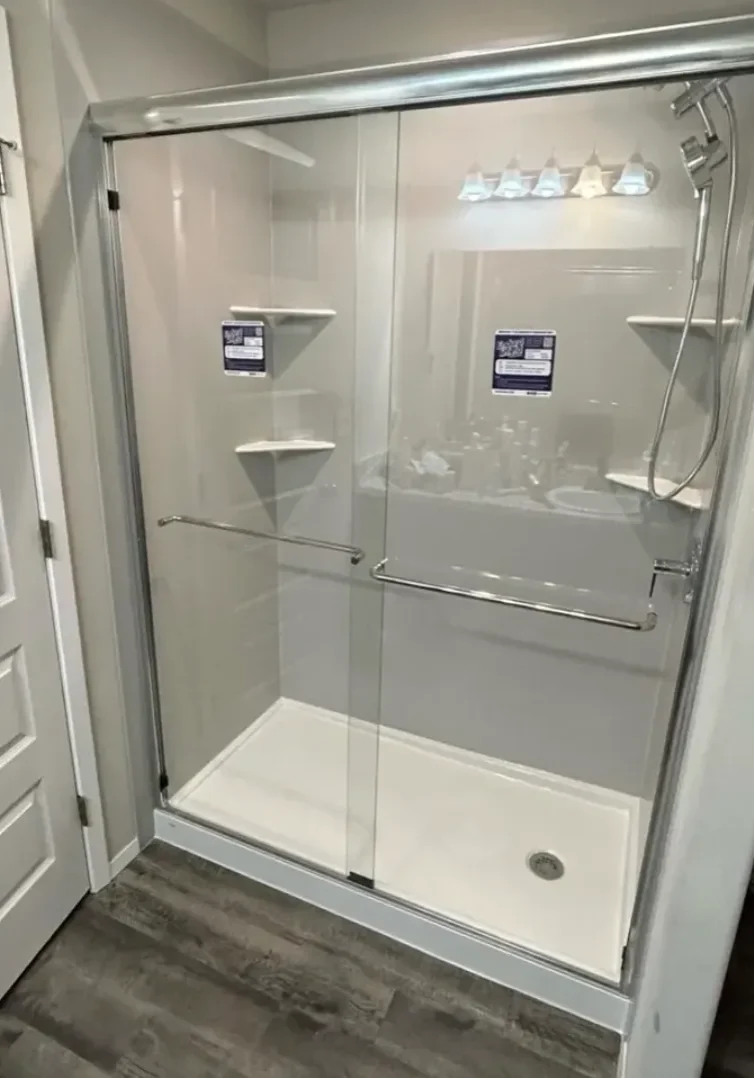 New glass shower enclosure installed in a modern bathroom.